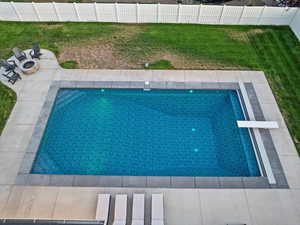 View of swimming pool featuring a fire pit, a diving board, and a patio
