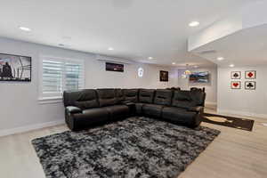 Living area with light wood-type flooring and recessed lighting