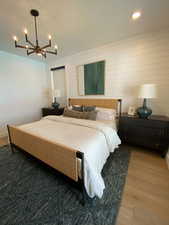 Bedroom with wood finished floors, a chandelier, and recessed lighting