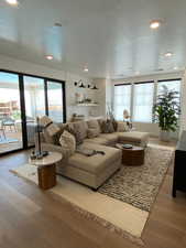 Living room featuring a textured ceiling, wood finished floors, and recessed lighting