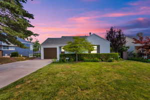 View of front with the driveway, a garage, and yard.