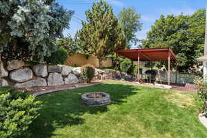 Fenced backyard with an outdoor fire pit and a deck