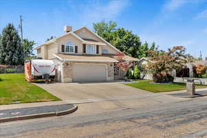 Traditional home with driveway, an attached garage, brick siding, and stucco siding