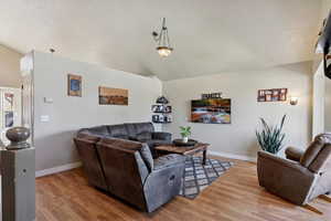 Living room with vaulted ceiling and light wood finished floors