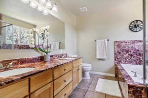 Full bathroom with double vanity, tile patterned flooring, and a garden tub