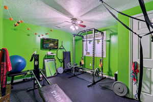 Workout area with a textured ceiling and ceiling fan