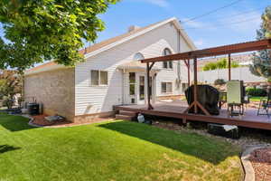 Back of property featuring a deck and brick siding