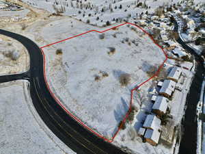 Snowy aerial view featuring property boundaries highlighted and a residential view