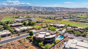 Aerial view of residential area featuring a golf club and a mountain backdrop