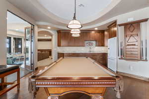 Rec room with arched walkways, recessed lighting, and wood-type flooring