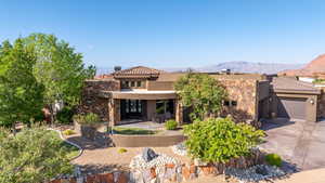 View of front of home with a mountain view, driveway, an attached garage, and stucco siding