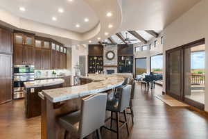 Kitchen with a large island, built in features, ceiling fan, dark wood finished floors, and recessed lighting