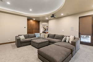 Living room featuring arched walkways, recessed lighting, and light carpet