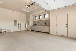 Garage featuring electric panel and strapped water heater