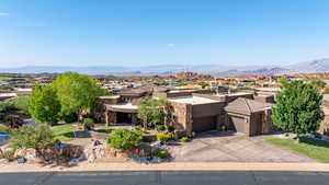 View of front of property featuring driveway, a mountain view, stucco siding, a residential view, and an attached garage