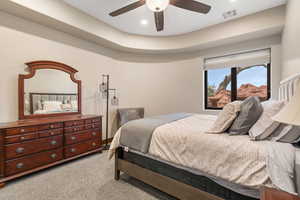 Bedroom featuring light colored carpet, recessed lighting, a ceiling fan, and a raised ceiling