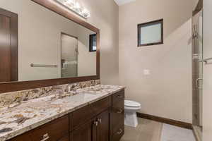 Bathroom with vanity, a shower stall, and tile patterned flooring