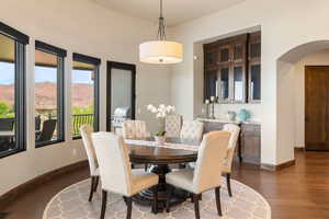 Dining space with arched walkways, dark wood finished floors, and a mountain view
