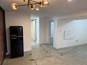 Unfurnished room with concrete flooring and a barn door