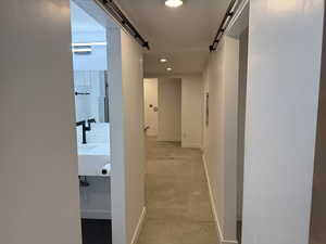 Corridor with a barn door and recessed lighting