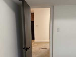 Corridor with a textured ceiling and concrete flooring