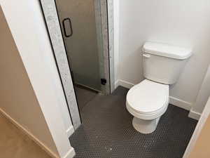 Full bathroom with toilet and a stall shower