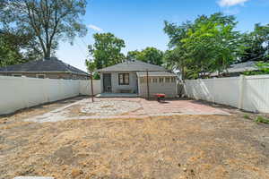 Back of house featuring a patio area, a fenced backyard, and a shingled roof