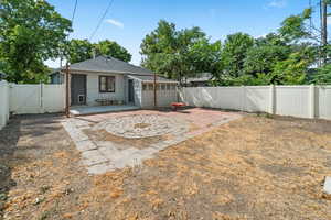 Fenced backyard featuring a patio area and a gate