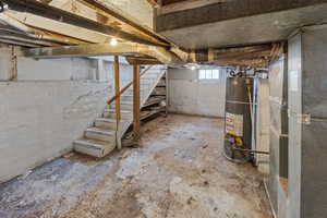 Below grade area featuring stairway, water heater, and heating unit