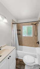 Full bathroom with shower / bath combo, vanity, wood finished floors, and a textured ceiling