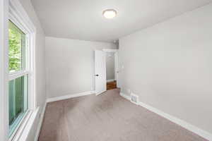 Empty room with carpet and baseboards