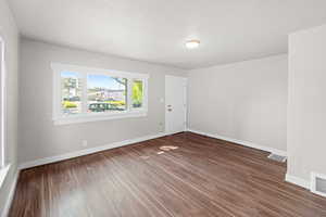 Unfurnished room featuring wood finished floors and baseboards