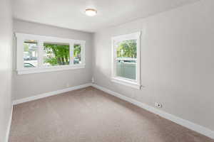 Carpeted spare room with baseboards