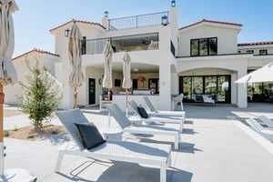 Rear view of property with a patio area, stucco siding, and a balcony
