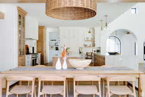 Kitchen with a center island with sink, recessed lighting, light countertops, decorative backsplash, and pendant lighting