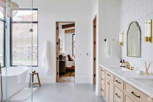 Bathroom with double vanity, a soaking tub, ensuite bath, decorative backsplash, and tile patterned floors