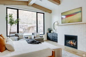 Bedroom featuring wood finished floors, wooden ceiling, and a tiled fireplace