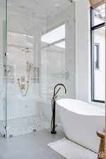 Full bath with a marble finish shower, a freestanding tub, and tile patterned floors