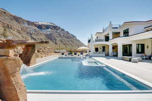 Outdoor pool with a patio, an outdoor living space, an in-ground hot tub, and a mountain view