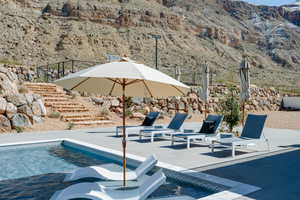 View of swimming pool featuring a patio area, a mountain view, and stairs