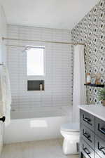 Bathroom featuring shower / tub combo with curtain, vanity, wood finished floors, and tile walls
