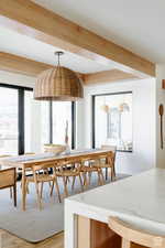 Dining room with beam ceiling and light wood-style flooring