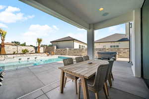 Fenced backyard with a hot tub and a patio