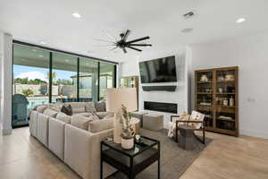 Living area featuring recessed lighting, ceiling fan, a fireplace, and floor to ceiling windows