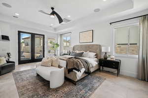 Bedroom featuring french doors, access to outside, a tray ceiling, recessed lighting, and ceiling fan