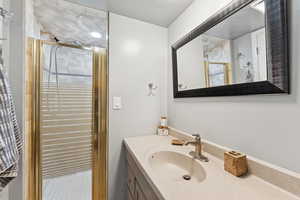 Bathroom featuring vanity and a shower stall