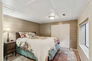Bedroom featuring wooden walls and a closet