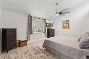 Bedroom with vaulted ceiling, wood finished floors, and a ceiling fan