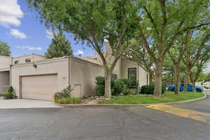 Mid-century home featuring stucco siding, an attached garage, and concrete driveway