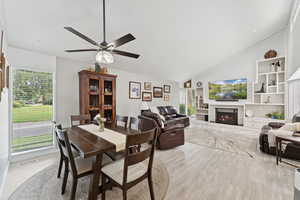 Dining room featuring healthy amount of natural light, light wood-style floors, a ceiling fan, and high vaulted ceiling